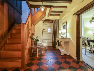 A hallway with a staircase and table at Bwthyn Canol in Llanfair