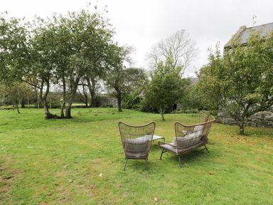 An outdoor seating area with chairs and a table at Bwthyn Canol in Llanfair