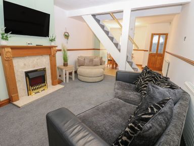 A living room with a fireplace and television at Bolton Terrace in Workington