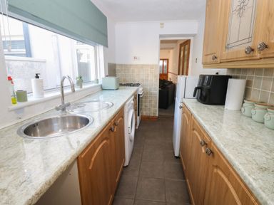 A kitchen with sink, stove, and washing machine at Bolton Terrace in Workington