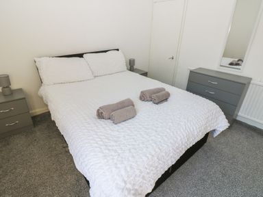 A bedroom with a bed and towels on it at Bolton Terrace in Workington