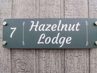 A house sign displaying the number 7 and Hazelnut Lodge at Hazelnut Lodge in Chipping Norton