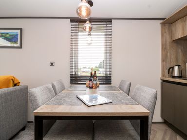 A dining room with a table and chairs at Hazelnut Lodge in Chipping Norton