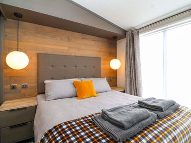 A bedroom with a bed and bedside lamps at Hazelnut Lodge in Chipping Norton