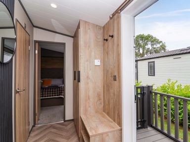 A hallway with a mirror and a sitting area at Hazelnut Lodge in Chipping Norton