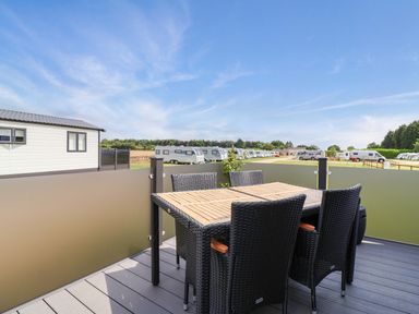 An outdoor seating area with table and chairs at Hazelnut Lodge in Chipping Norton