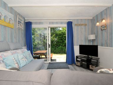 A snug with a sofa and a tv at 8 Hillside in Bude