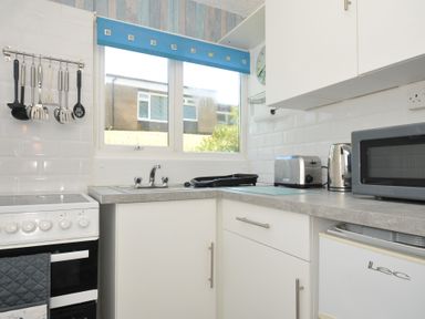 A kitchen with stove, sink and appliances at 8 Hillside in Bude
