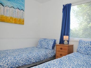 A bedroom with two beds and a bedside table at 8 Hillside in Bude