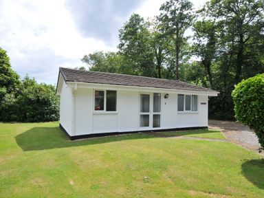 A bungalow with a front door and windows at 4 Rosecraddoc Lodge Holiday Bungalows in Liskeard