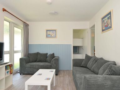 A living room with a sofa and coffee table at 4 Rosecraddoc Lodge Holiday Bungalows in Liskeard