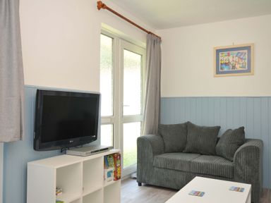 A living room with television and sofa at 4 Rosecraddoc Lodge Holiday Bungalows Liskeard