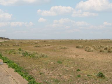 A grassy area with a sandy pathway and scattered clouds at No. 2 - Seaview in Kessingland