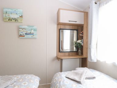 A bedroom with a mirror and two beds at No. 2 - Seaview in Kessingland