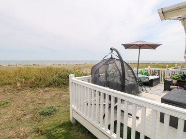A deck with a hanging chair and outdoor furniture at No. 2 - Seaview in Kessingland
