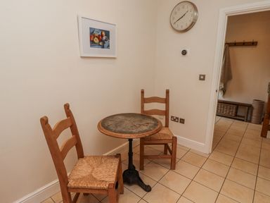 A dining room with a table and two chairs at Watermill Cottage in North Charlton