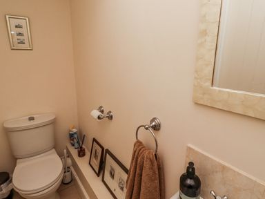 A bathroom with a toilet and towel holder at Watermill Cottage in North Charlton