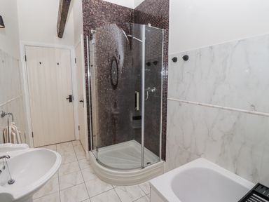 A bathroom with a shower and sink at Watermill Cottage in North Charlton