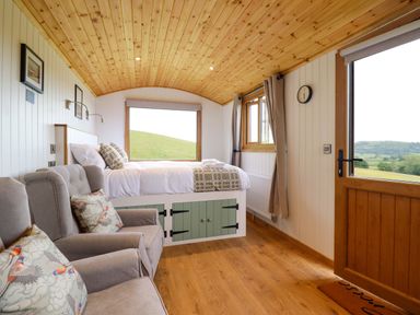 A sleeping area with a bed and sofa at Defaid Cymreig in Oswestry