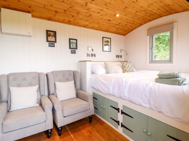 A bedroom with a bed and armchairs at Cheviot in Oswestry