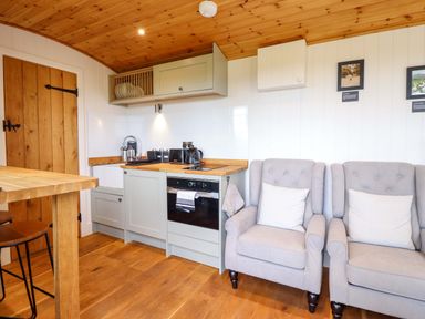 A kitchen with cabinets and seating area at Cheviot in Oswestry