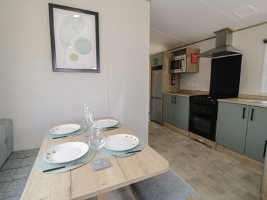 A dining area with a table set for four at Puffin Way Holiday Caravan