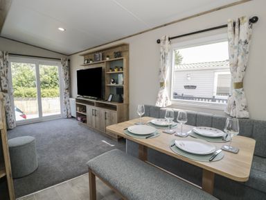 A dining room with a table and chairs at Puffin Way Holiday Caravan