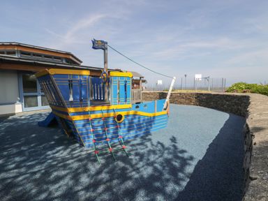 A playground with a pirate ship climbing structure at Puffin Way Holiday Caravan