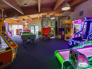 An indoor amusement area with arcade machines and a pool table at Puffin Way Holiday Caravan