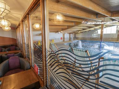 An indoor pool area with seating and a swimming pool at Puffin Way Holiday Caravan