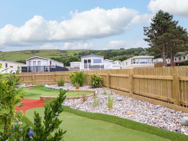 An outdoor area with caravans and landscaped garden at 8 Puffin Way Llwyngwril