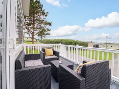 An outdoor seating area with chairs and a table at 8 Puffin Way Llwyngwril