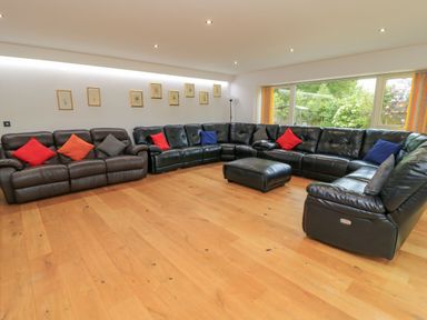 A living room with a sectional sofa and ottoman at Silver Copse Frilford Heath Near Abingdon