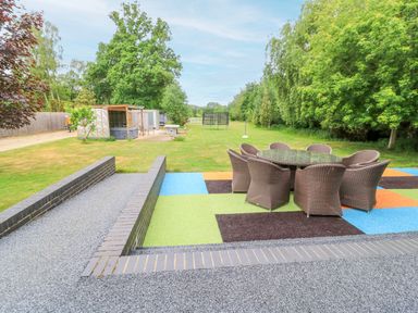 A garden with a dining table and chairs at Silver Copse Frilford Heath Near Abingdon
