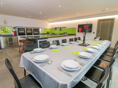 A dining room featuring a long table set for a meal at Silver Copse Frilford Heath Near Abingdon