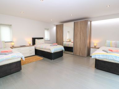 A bedroom with two beds and a wardrobe at Silver Copse Frilford Heath Near Abingdon