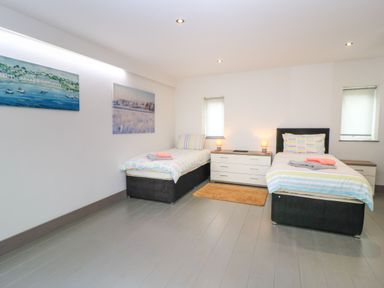 A bedroom with two beds and a dresser at Silver Copse Frilford Heath Near Abingdon
