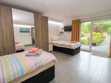 A bedroom with two beds and a television at Silver Copse Frilford Heath Near Abingdon