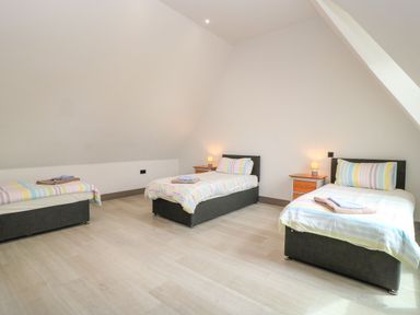 A bedroom with three beds and nightstands at Silver Copse in Frilford Heath Near Abingdon