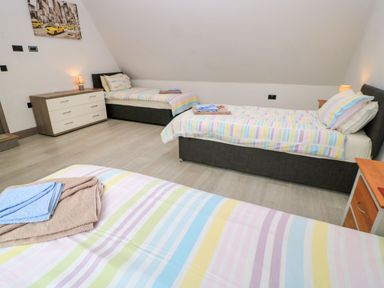A bedroom with two beds and a chest of drawers at Silver Copse in Frilford Heath Near Abingdon