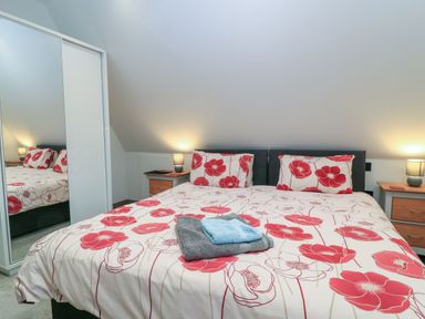 A bedroom with a bed and bedside tables at Silver Copse in Frilford Heath Near Abingdon
