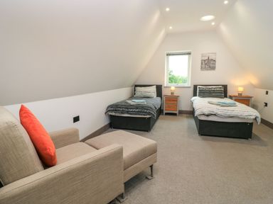 A bedroom with two beds and a seating area at Silver Copse Frilford Heath Near Abingdon