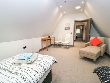 A bedroom with a bed and chairs at Silver Copse Frilford Heath Near Abingdon