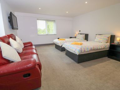 A bedroom with two beds and a sofa at Silver Copse in Frilford Heath Near Abingdon