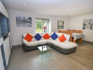 A living room with a sectional sofa and dining table at Silver Copse Frilford Heath Near Abingdon