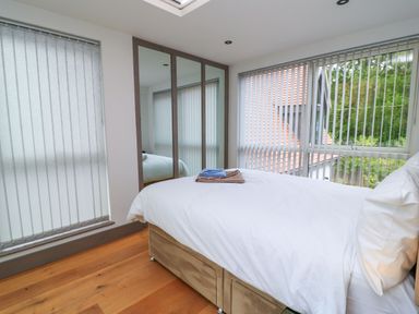 A bedroom with a bed and mirror at Silver Copse Frilford Heath Near Abingdon