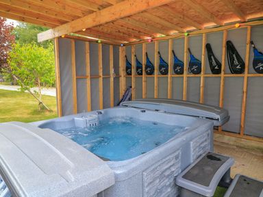 A hot tub surrounded by wooden beams and paddles at Silver Copse in Frilford Heath Near Abingdon