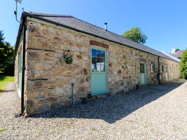 An exterior view of a stone building with a green door at Carreg Las Haverfordwest