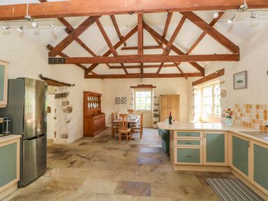 A kitchen with a dining table and chairs at Carreg Las in Haverfordwest
