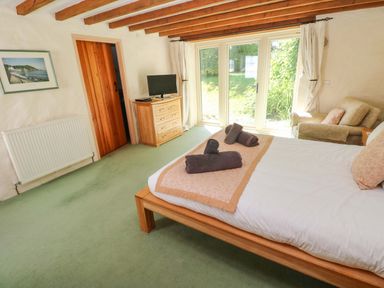 A bedroom with a bed and dresser at Carreg Las in Haverfordwest
